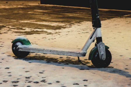 city electric scooter stands in the snow in winterの写真素材