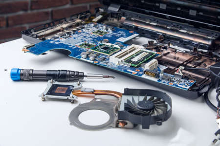 disassembled laptop, computer workshop, cooling system, screwdriverの写真素材