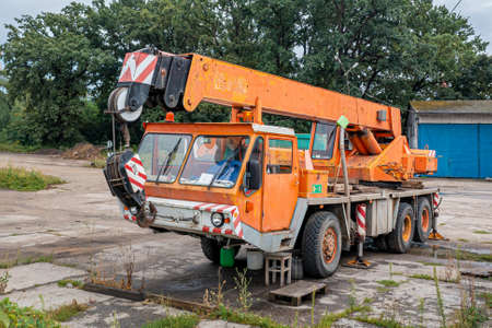 Old orange truck crane stands in the parking lotの写真素材