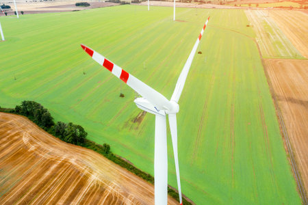 Wind turbine generating electricity, windmills against the background of a green field, an...