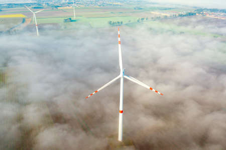 Aerial view of wind turbine in fog, environment, renewable energy, power generation, summer landscape, droneの写真素材