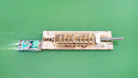Top view of Tugboat pushing a heavy barge on the riverの写真素材