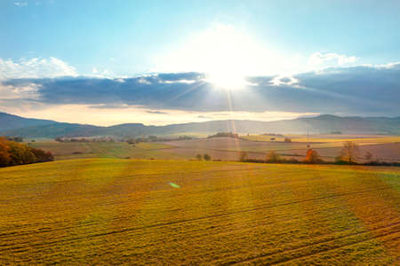 Beautiful summer landscape, green fields, trees and the setting sun against the blue sky. Poland, Klodzkoの写真素材