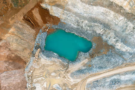 A blue lake in a quarry, an orange-colored sand quarry from a bird's eye viewの写真素材