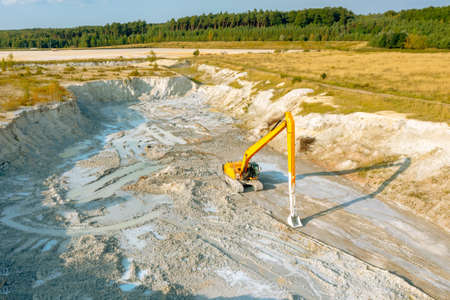 An excavator at a construction site plans the ground before work on the foundationの写真素材