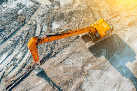 An excavator at a construction site plans the ground before work on the foundationの写真素材