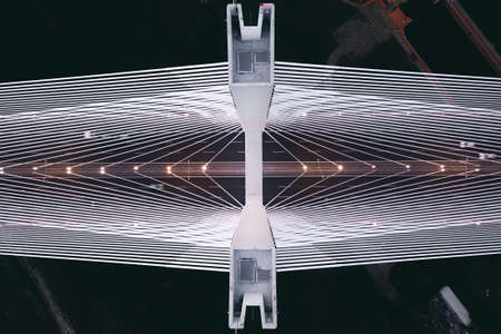 Steel pylon of the bridge at night from a height and the freeway from belowの写真素材