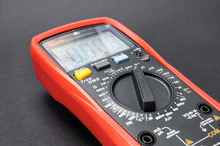 Red multimeter, multimeter or multitester, modern multifunctional voltage measuring instrument on...
