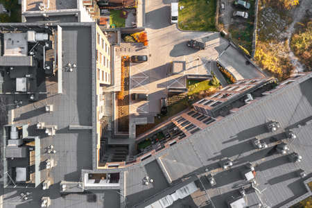 Top view of the roofs of multi-storey buildings, many ventilation pipes on the roof of the house and various communications from aboveの写真素材