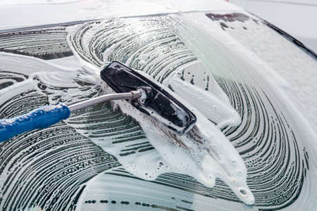 Chemical detergent for car cleaning. Car in white foam. carwash.の写真素材