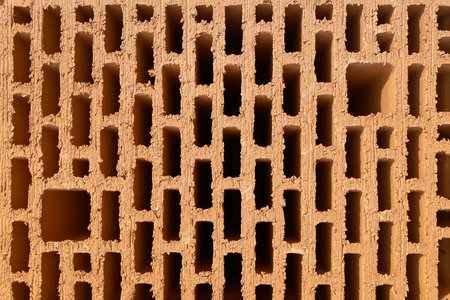 A stack of bricks made of red light clay. Environmentally friendly building material, hollow clay...