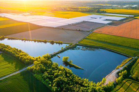 Greenhouse for vegetables and next to a small lake for watering vegetables. view from above.