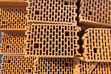 A stack of bricks made of red light clay. Environmentally friendly building material, hollow clay...