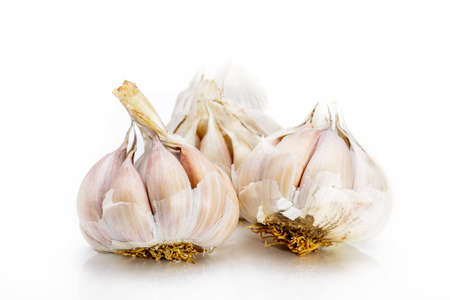 A lot of unpeeled garlic on a white backgroundの写真素材