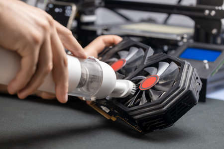 Cleaning the computer from dust and dirt with a vacuum cleaner, video card and computer CPU heatsinkの写真素材