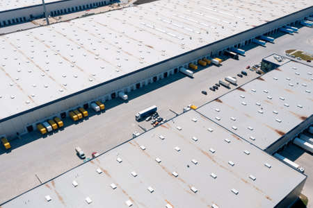 Aerial view of a warehouse of goods. Logistic warehouse buildings and many trucks loading goodsの写真素材