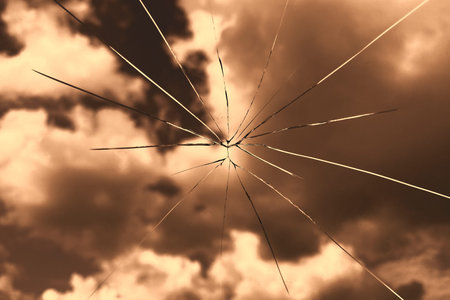 Cracked glass against the blue sky, windshield crack