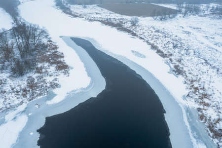 Aerial view of the river covered with ice, thaw, melting ice on the riverの写真素材
