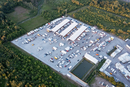 Aerial view of the goods warehouse. Logistics center in the industrial area of the city with a lot of carsの写真素材