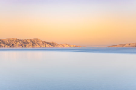 Sunset in a calm sea in the evening in good weather, sandy islands in the distance, rest on the seaの写真素材