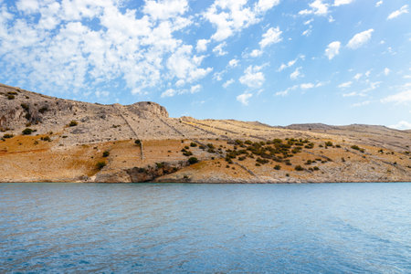 Sandy lonely islands and hills on the coast of the blue sea, landscape photography of uninhabited islands, large overhanging rocks. Island of Pag, Croatiaの写真素材