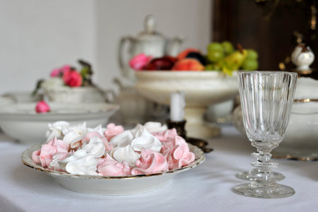 White and pink meringues on a porcelain plate. Sweet dessert.