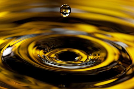a drop falling in golden watersの写真素材