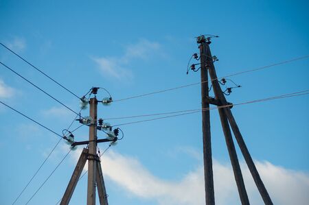 Close-up of old power lines against the blue skies and cloudsの写真素材