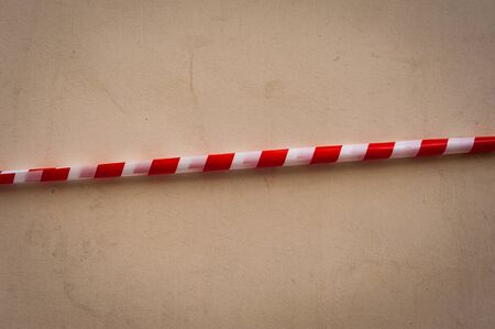 Red-and-white brrier tape on the wall of the old houseの写真素材