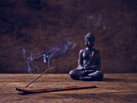 Buddha on wood with joss stick when litの写真素材