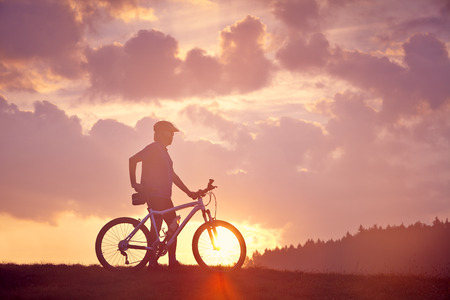 Man and mountain bike in the sunriseの写真素材