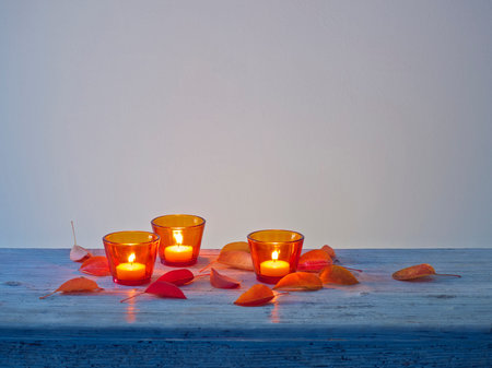Candles on the table in red glasses