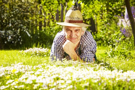 Man with hat in field of flowers lyingの写真素材