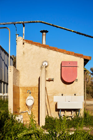 Urinal and sink and toilet sheds at a campsite in the south of France with cloudless sky