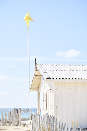 Hut on a beach with yellow flag and sea view with sky and cloudsの写真素材