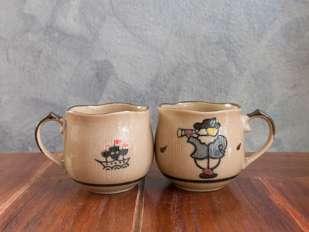 A couple painted tea cup on wooden table. Copy spaceの写真素材