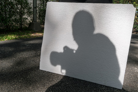 Shadow of a photographer holding camera on foam boardの写真素材