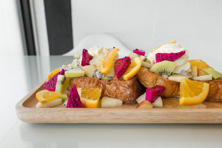 Close up of French toast with kiwi, apple, Dragon Fruit, orange and honey