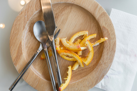 Orange peel in plate after eat dessertの写真素材