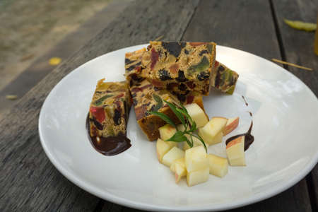 delicious sliced fruit cake with mixed fruit on wooden tableの写真素材