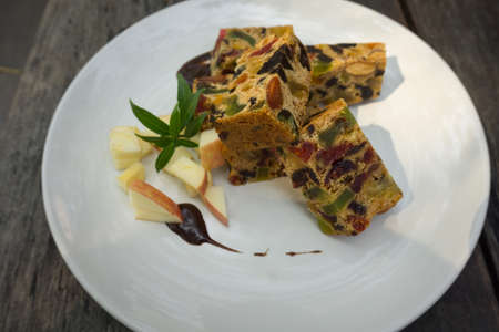 delicious sliced fruit cake with mixed fruit on wooden tableの写真素材