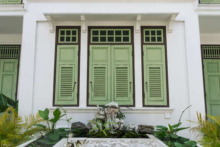 vintage green wooden shutter window on white building, Thailandの写真素材