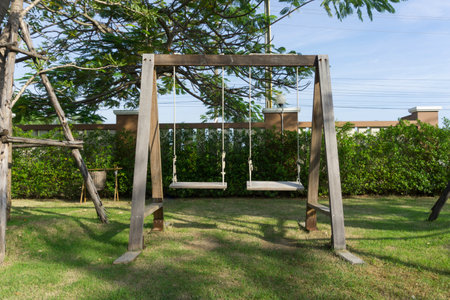 Wooden swing on the green grass in the garden, Thailand.の写真素材