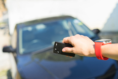 Women's hand with smart watch presses on the remote control car alarm systemsの写真素材