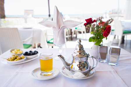 Moroccan mint tea in glass with teapot on the table in cafe. Close up.の写真素材
