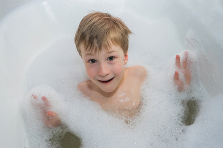 Little  happy boy in  foam soap  in the bathroom .の写真素材