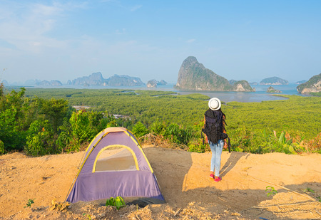 Hiker with backpack standing on top of the mountain  in camping and enjoying valley viewの写真素材