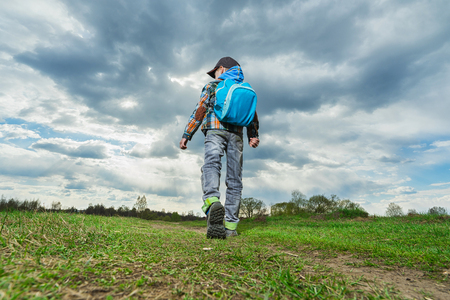 Little   boy with backpack walking in nature. Travel concept.の写真素材