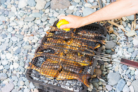 Fish barbecue on the beach. Selective focus.の写真素材