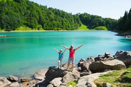 Mother and son on the beautiful  mountain green lake. Travel concept.の写真素材
